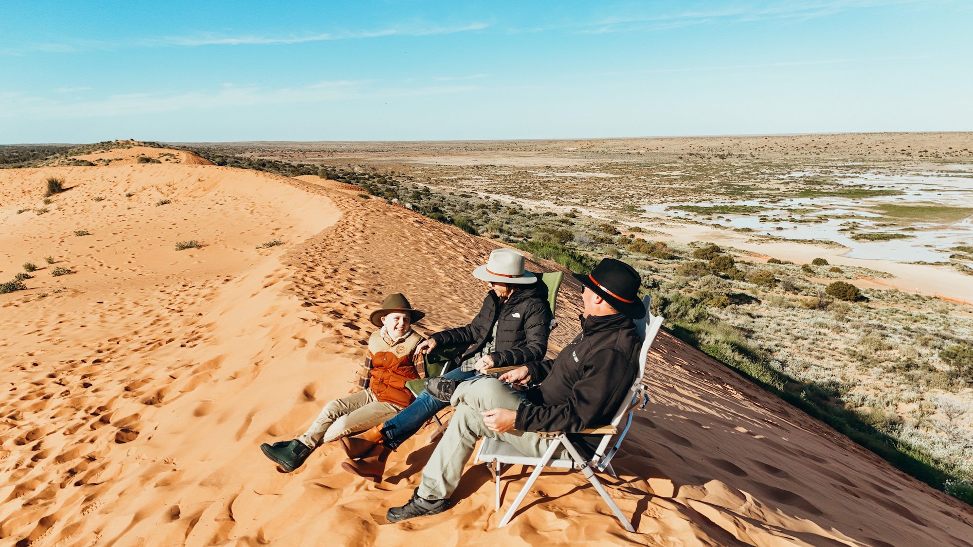 Family sitting on top of Big Red Sand Dune Simpson Desert, Outback Queensland