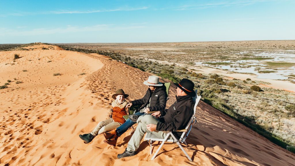 Family sitting on top of Big Red Sand Dune Simpson Desert, Outback Queensland
