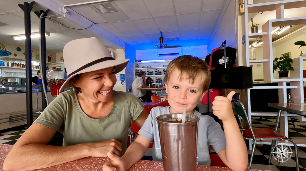 Mother and son enjoying a milkshake, old school milk bar