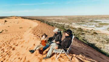 Family sitting on top of Big Red Sand Dune Simpson Desert, Outback Queensland