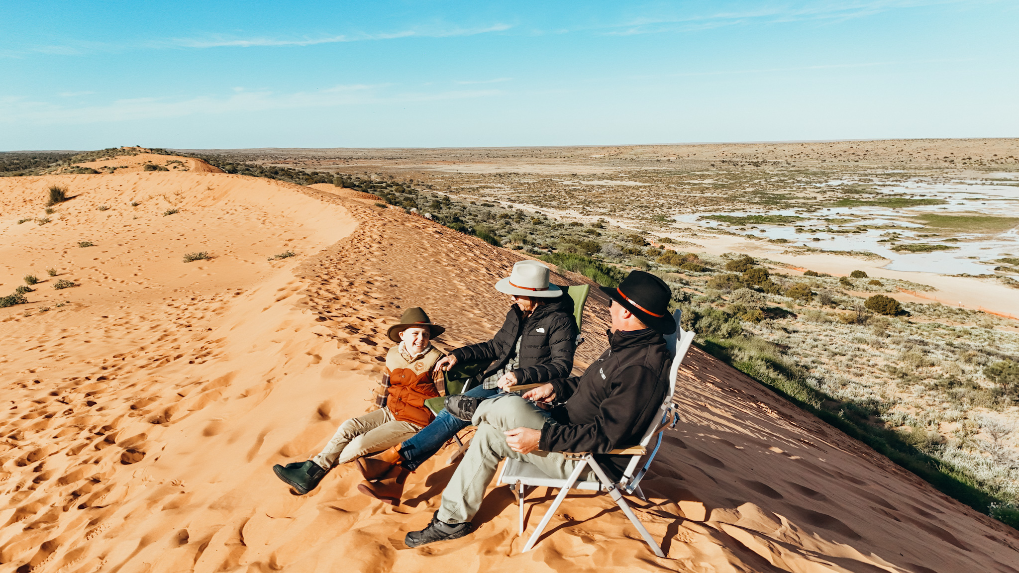 Family sitting on top of Big Red Sand Dune Simpson Desert, Outback Queensland